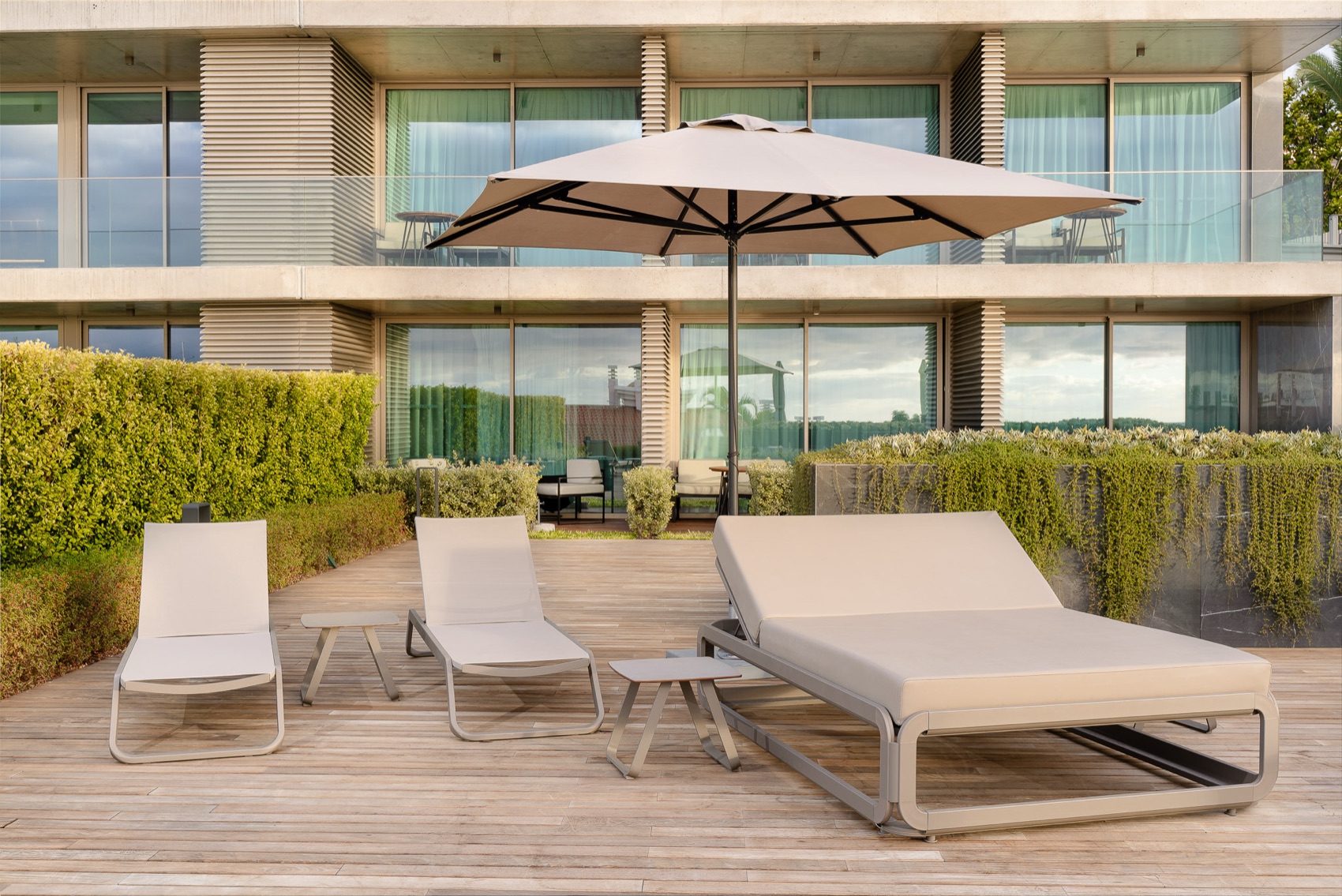 Ezpeleta double daybed and loungers under a parasol on a modern deck