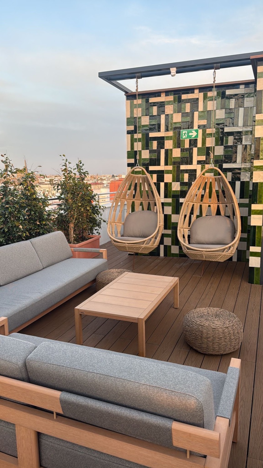 SKLD Studio rooftop lounge with hanging rattan chairs and sofas